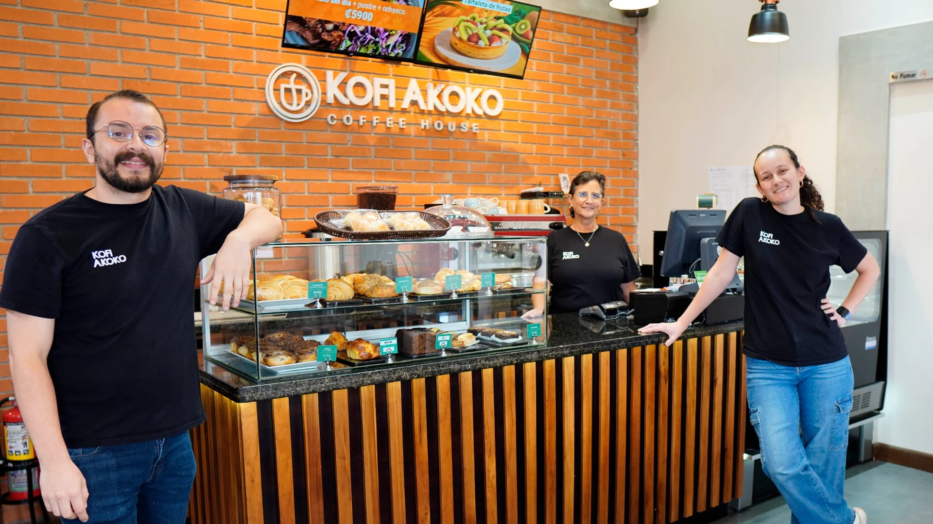 El equipo de Kofi Akoko junto a la vitrina de repostería en la cafetería